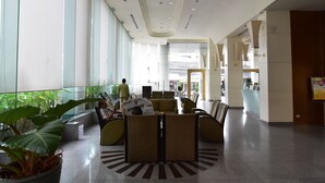 Un'ampia hall con zone relax, ampie finestre e una reception.