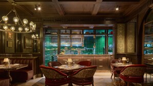 Un restaurante con zona de bar, techo de madera y salpicadero de azulejos verdes.