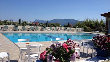 Piscine extérieure, parasols de plage, chaises longues