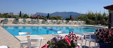 Piscine extérieure, parasols de plage, chaises longues