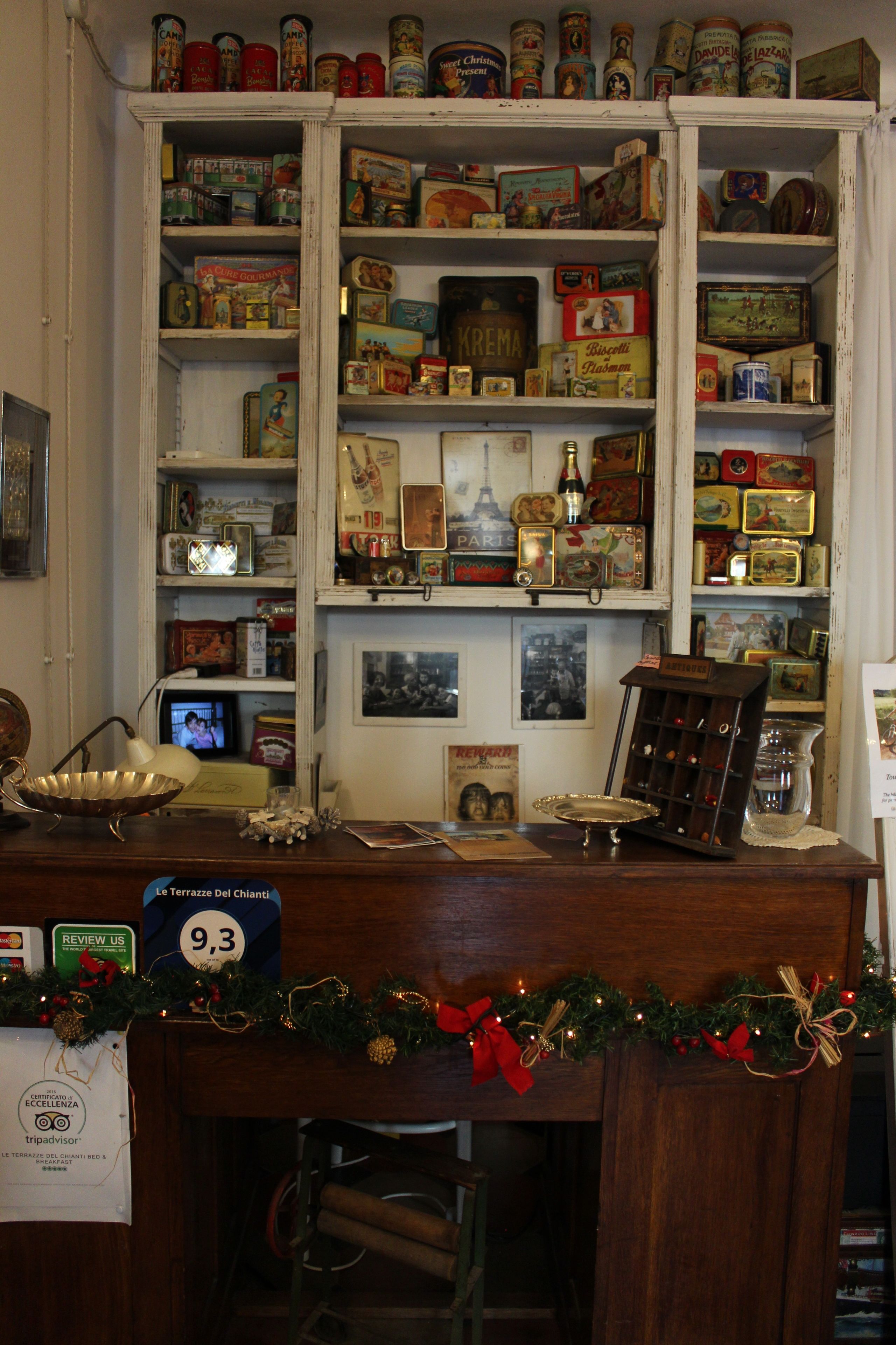 Une boutique d’antiquités où l’on trouve des étagères remplies de vieilles boîtes de conserve, un comptoir en bois avec une enseigne et une petite télévision.