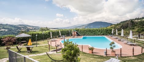 Piscine extérieure, parasols de plage, chaises longues