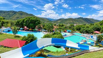 A water park with multiple pools and a large blue and white slide.