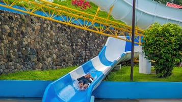 A water slide at a water park with a pool at the bottom.