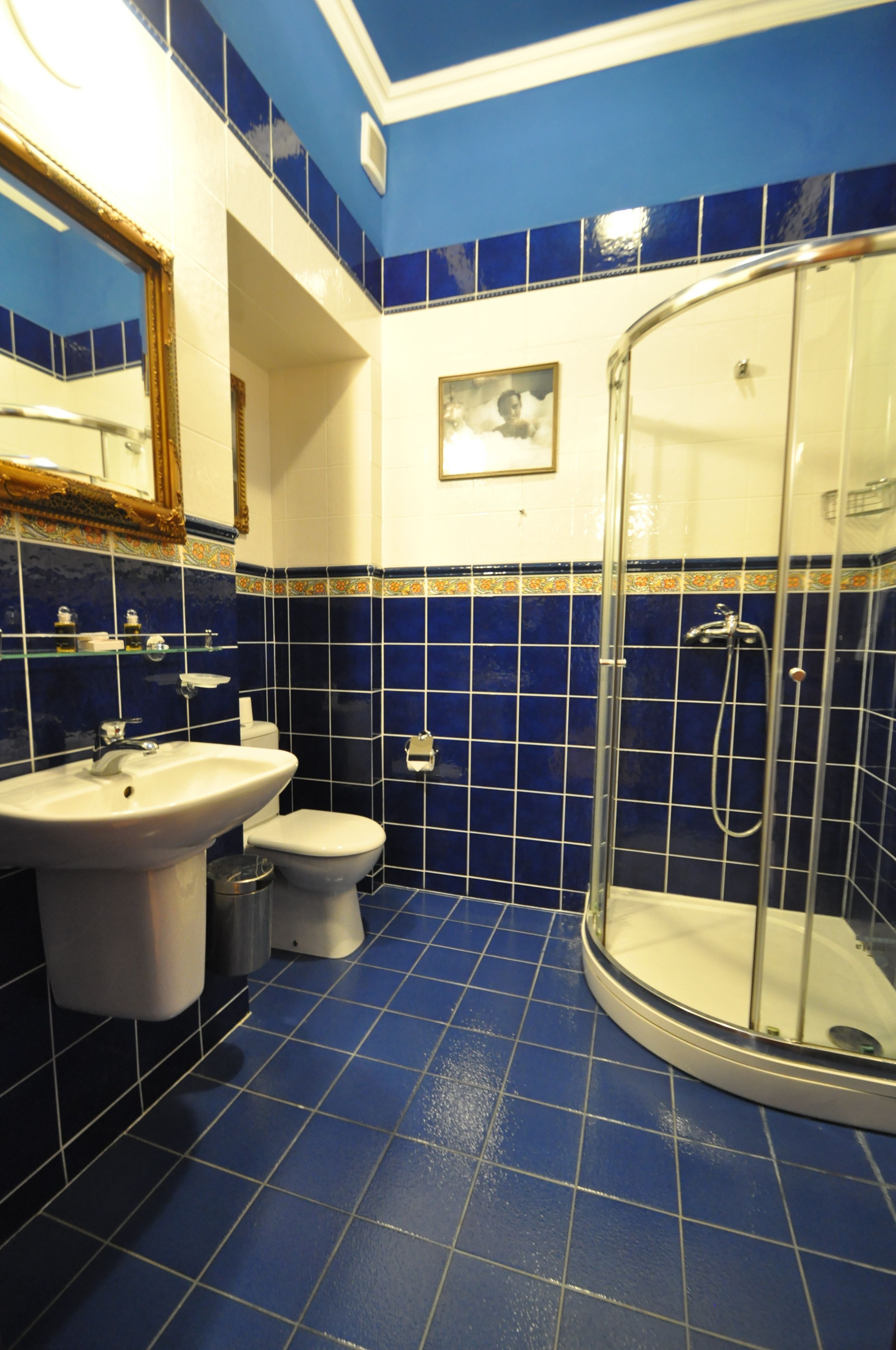 A bathroom with a sink, toilet, and glass-enclosed shower.