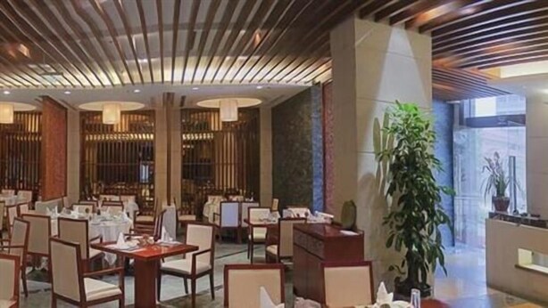 A spacious lobby with multiple seating areas, a large plant, and a well-lit reception area. - Empark Grand Hotel (Xishuangbanna Dai)