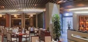 A spacious lobby with multiple seating areas, a large plant, and a well-lit reception area. - Empark Grand Hotel (Xishuangbanna Dai)