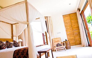A bedroom with a four-poster bed, a wooden wardrobe, and a large window.