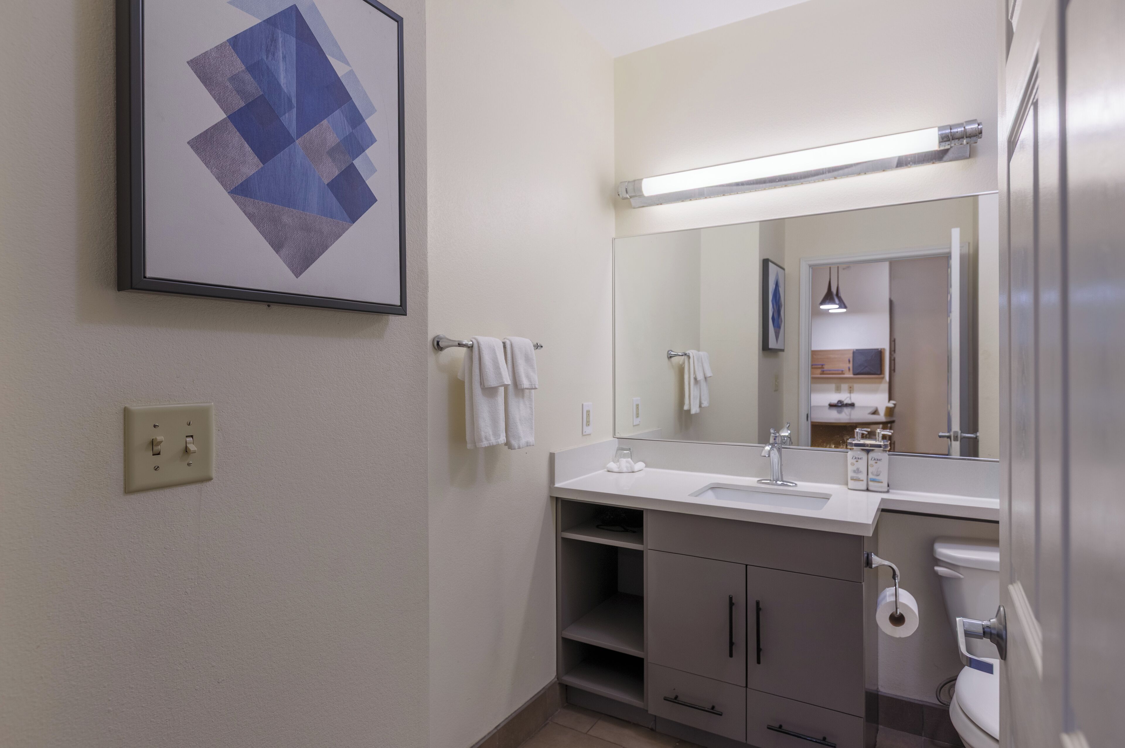 A bathroom with a sink, mirror, towel rack, and toilet.