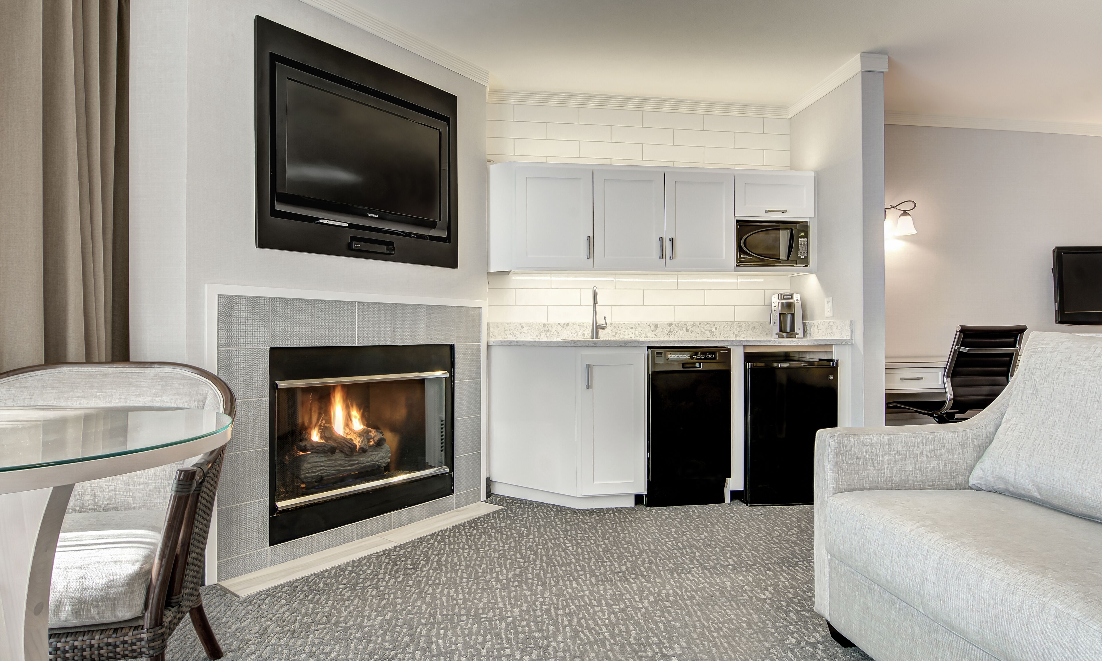A modern kitchen with white cabinets, a built-in microwave, and a dishwasher.