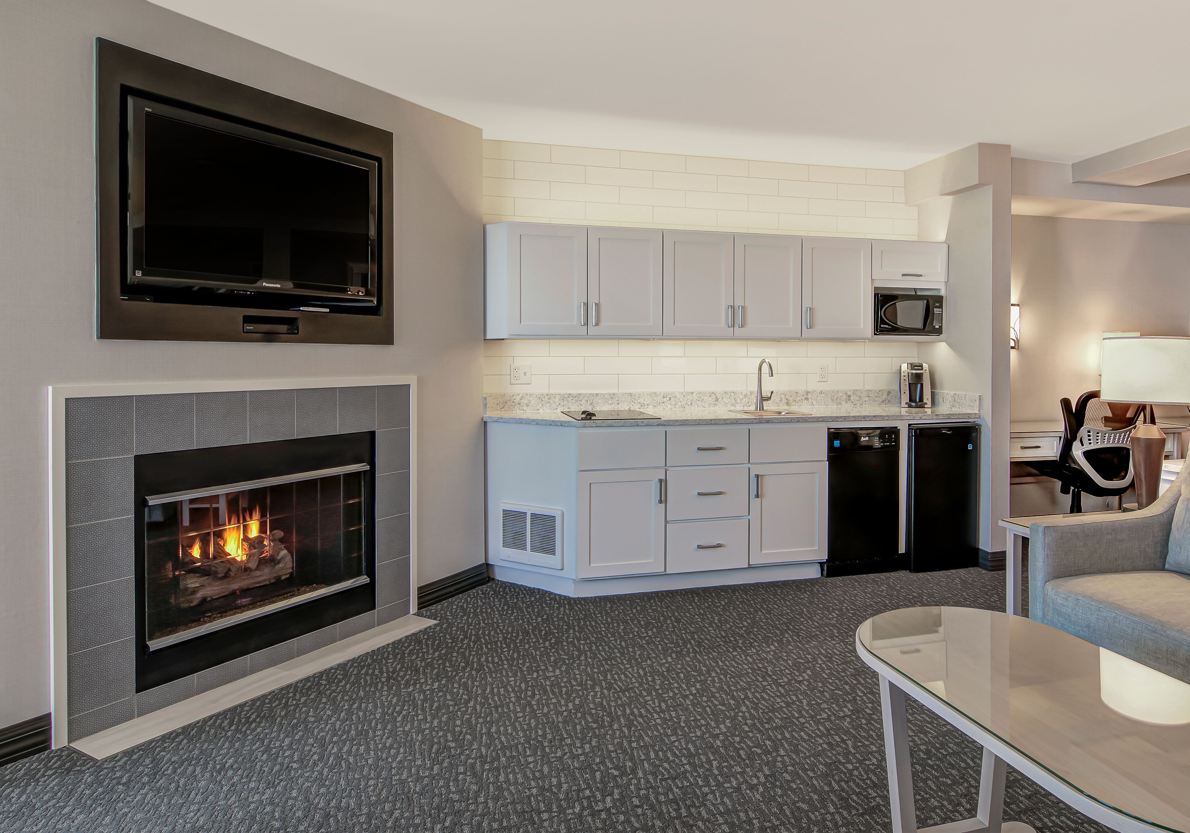 A modern kitchen with white cabinets, a microwave, and a dishwasher.