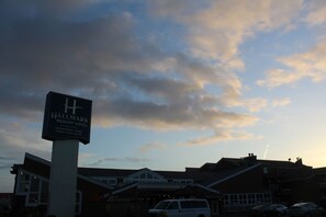 A sign for Hallmark Resort Hotel with a view of the building and parked cars. - Hallmark Resort - Newport (Newport)