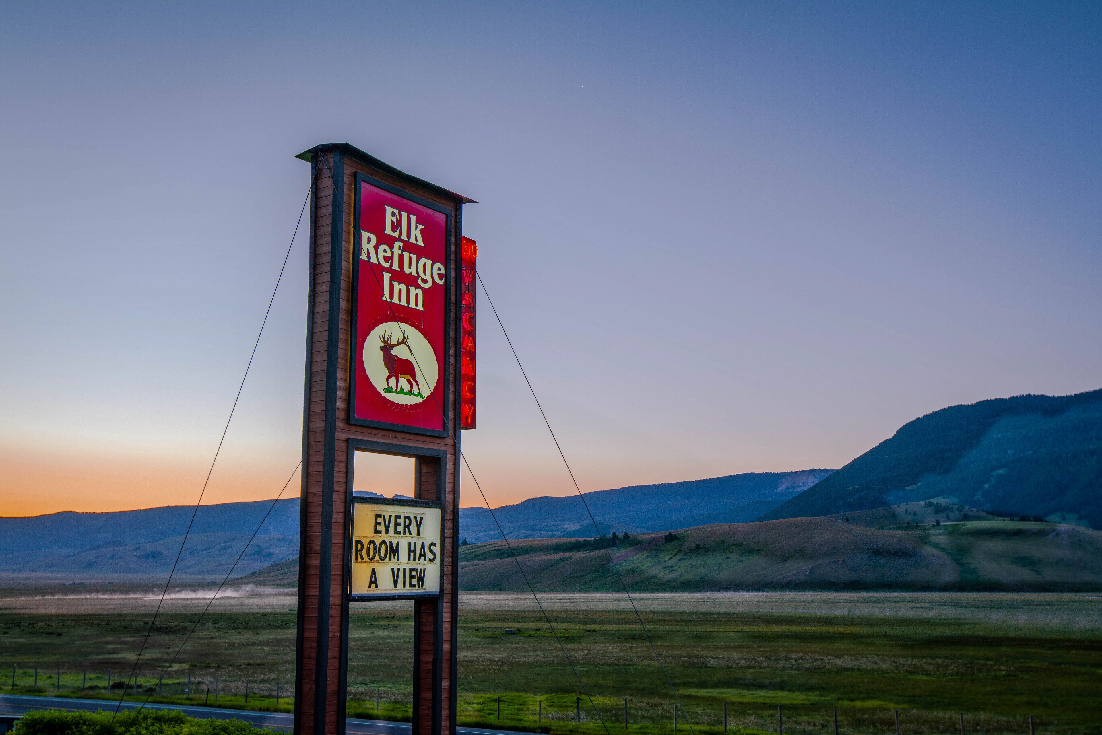 Señal del Elk Refuge Inn con vistas al paisaje circundante.