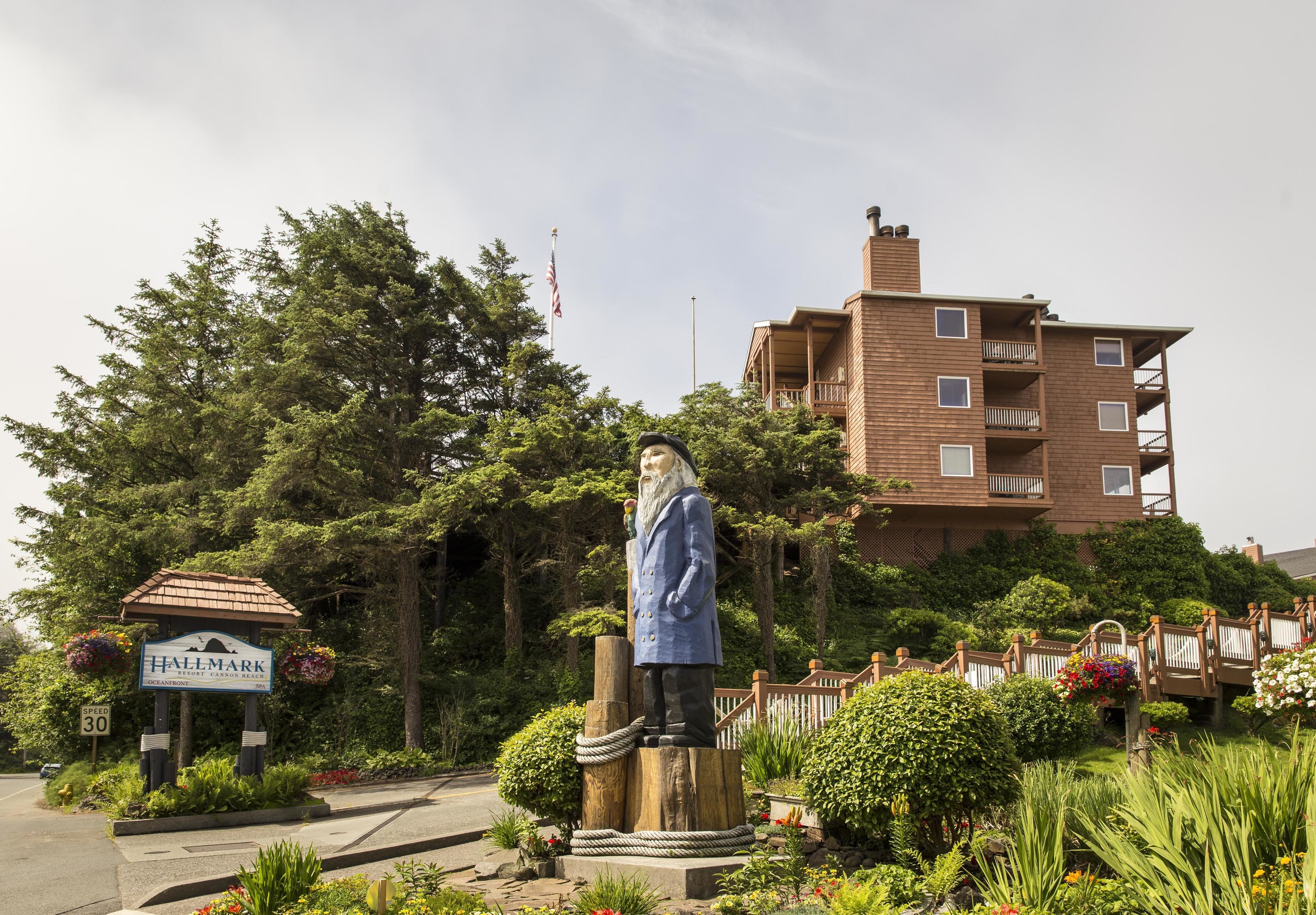 A statue in front of a building with a sign that reads "HALLMARK".