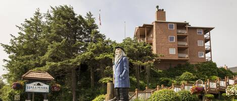 A statue in front of a building with a sign that reads "HALLMARK".