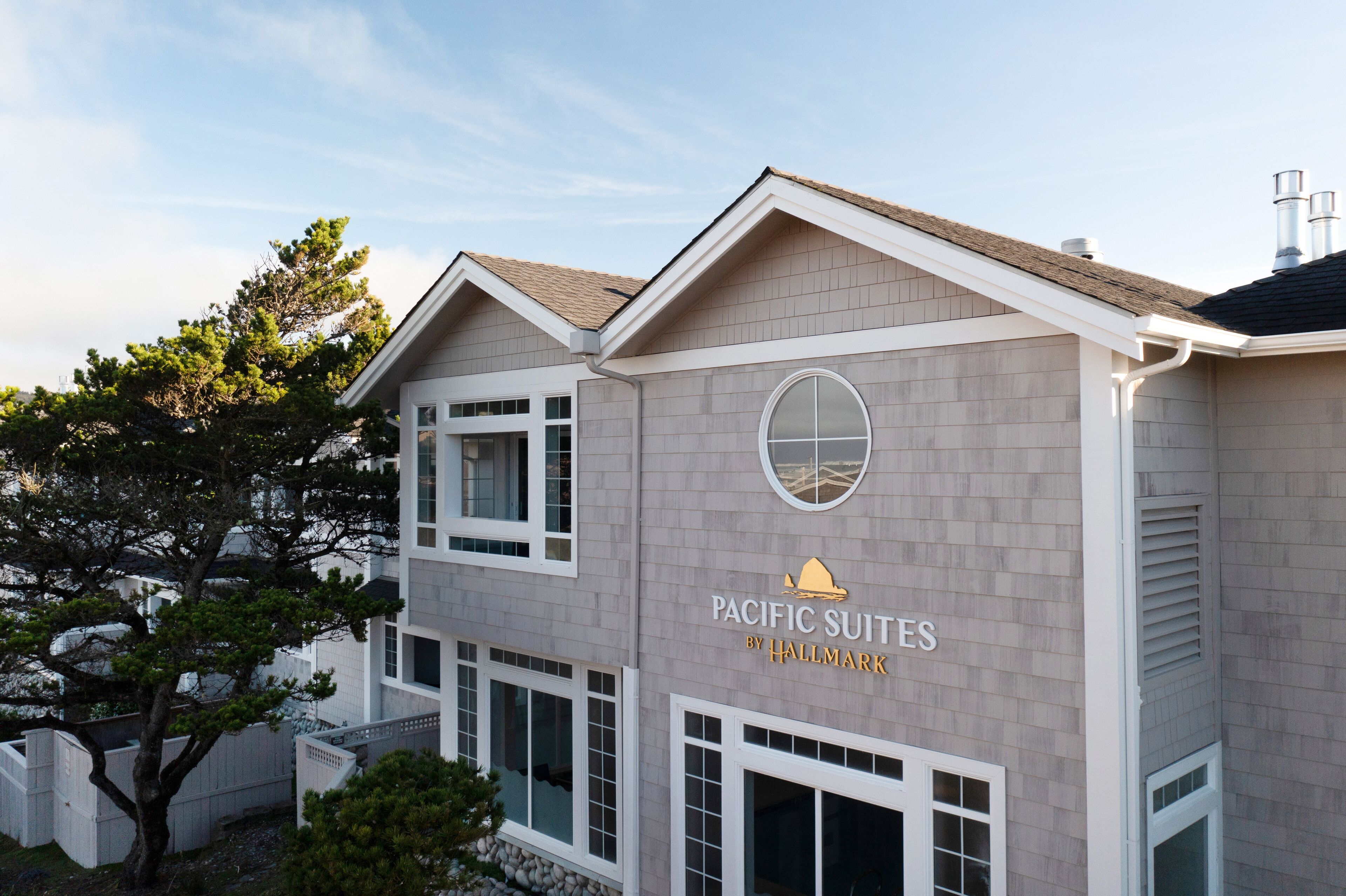 A two-story building with a sign reading 'Pacific Suites by Hallmark.'