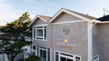 A two-story building with a sign reading 'Pacific Suites by Hallmark.'