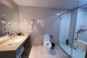 Une salle de bain moderne avec une douche à parois de verre, un meuble-lavabo à deux vasques et des toilettes.