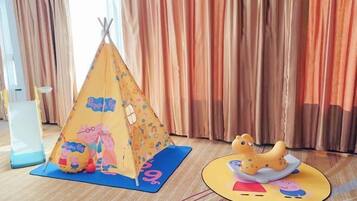 A children's play area with a tent and a play mat featuring Peppa Pig characters.