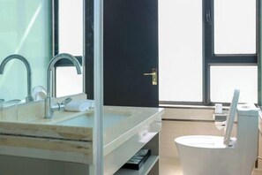 Une salle de bain moderne avec un grand miroir, un lavabo et des toilettes.