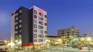 A multi-story hotel with a modern design, featuring a prominent Hilton Garden Inn sign. - Hilton Garden Inn Queretaro (Querétaro)