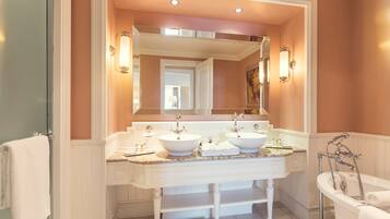A bathroom with two sinks, a large mirror, and a bathtub.