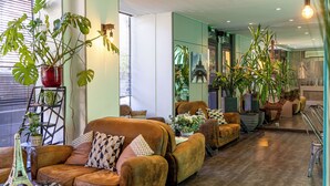 Una sala de estar moderna con sofás de cuero, plantas en macetas y una reproducción de la Torre Eiffel.