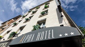 Un hotel con un letrero que dice "ALPHA HOTEL" y tres estrellas.
