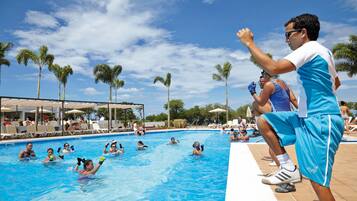 Relax by the pool surrounded by palm trees and lounge chairs.