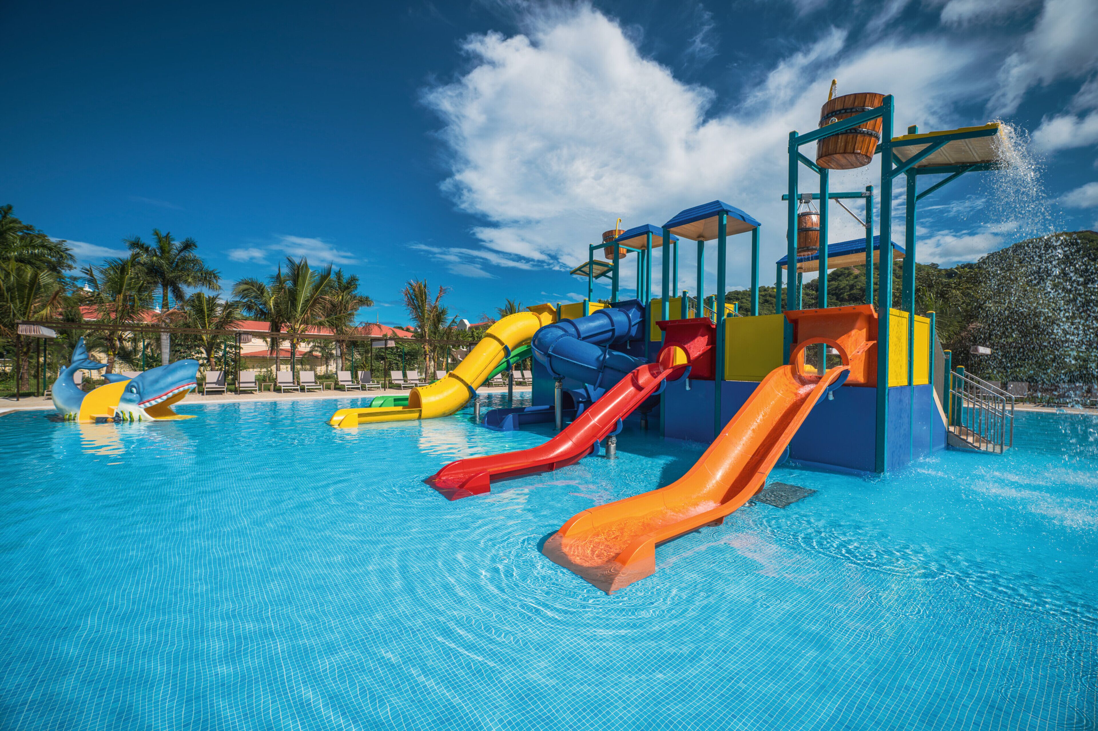 Een waterpark met meerdere glijbanen en een zwembad.