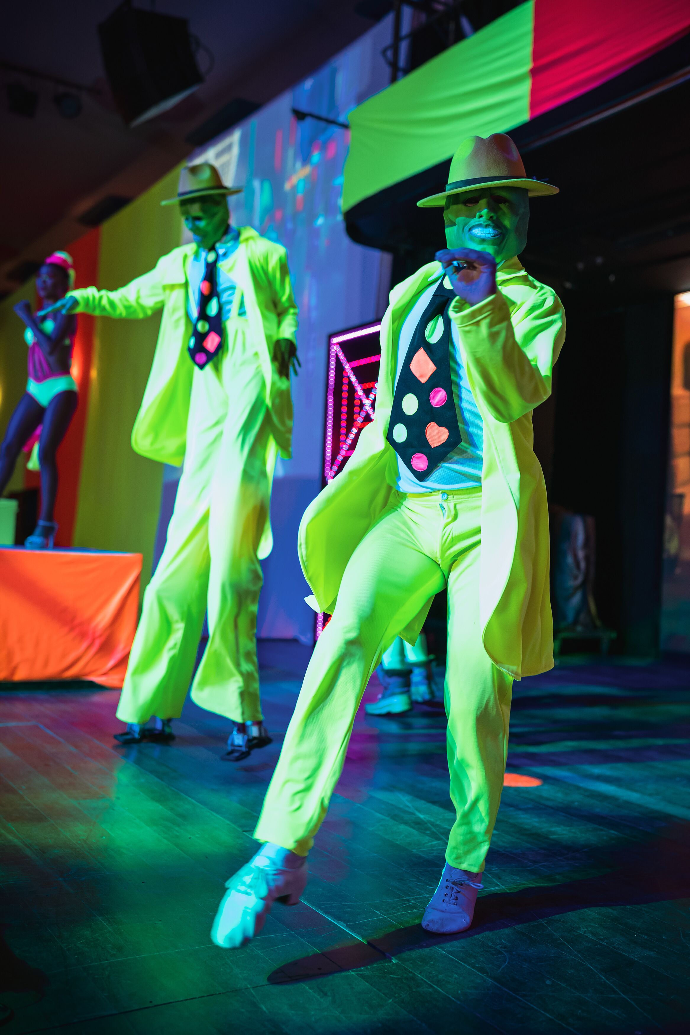 A stage with performers in bright yellow outfits and hats.