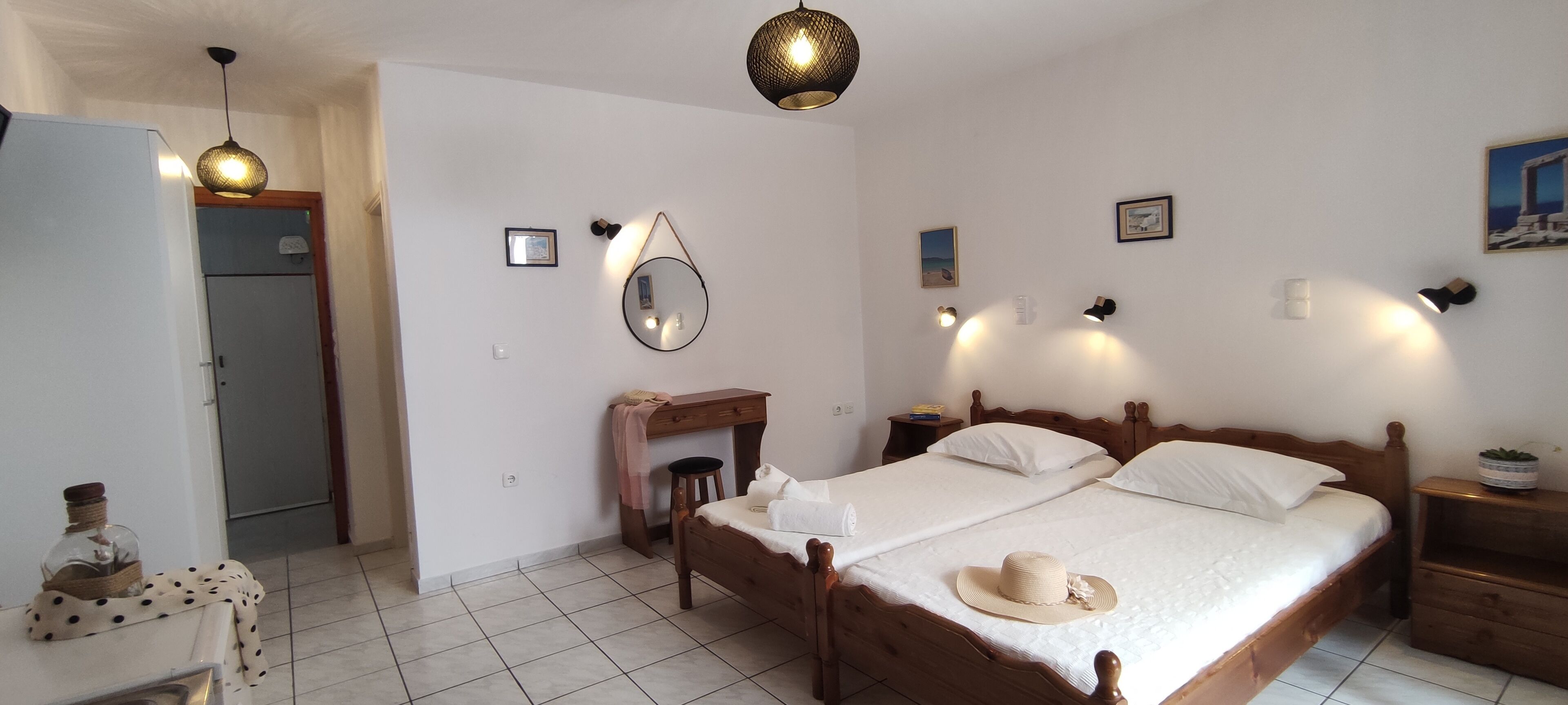 Un dormitorio con cama de madera, escritorio, espejo y armario.