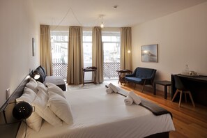 A hotel room with a large bed, a desk, a chair, and a balcony with curtains. - Cale Guest House (Porto)