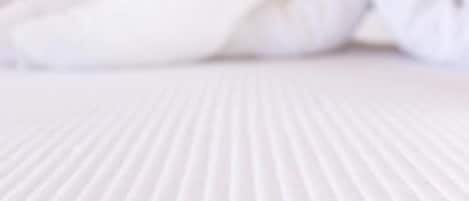 A bed with a heart-shaped towel arrangement.