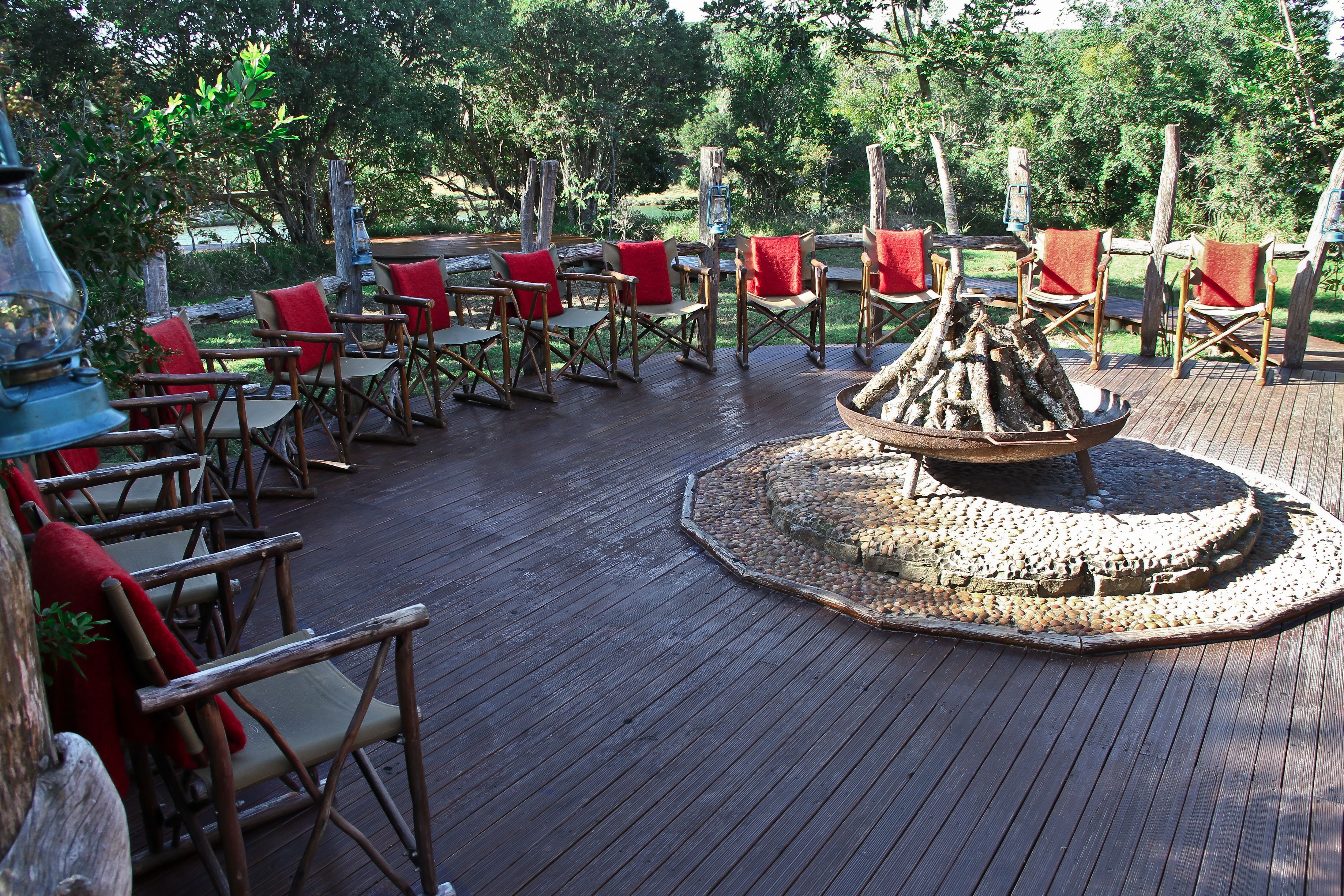 An outdoor seating area with wooden deck chairs and a central fire pit.