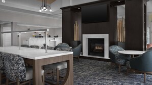 A modern hotel lobby with a bar area, seating, a fireplace, and a flat-screen TV mounted on the wall. - Homewood Suites by Hilton Orlando Airport (Orlando)