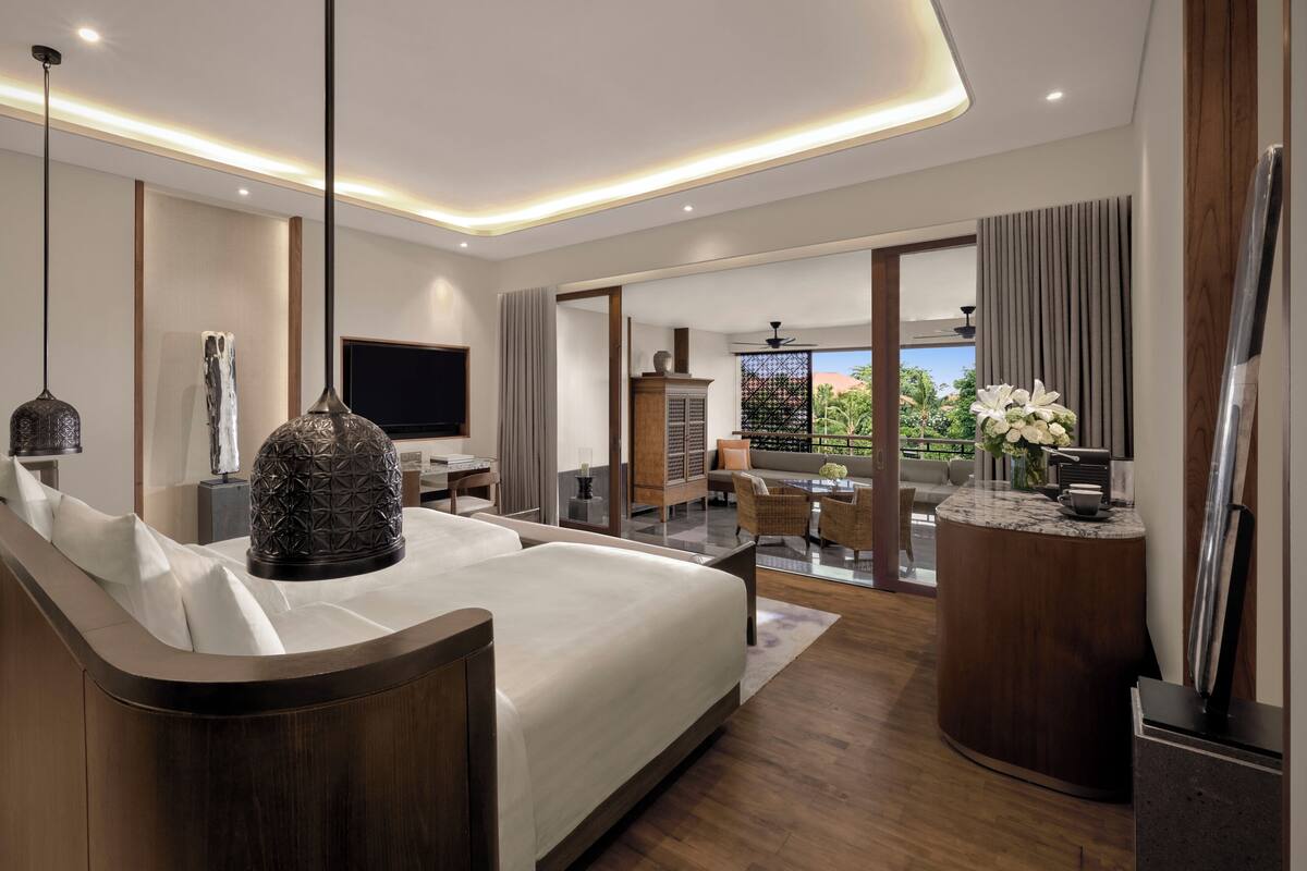 Une chambre d’hôtel moderne avec un grand lit, un bureau et un balcon offrant une vue agréable.