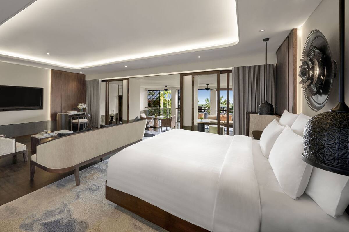 Une chambre d’hôtel moderne équipée d’un grand lit, d’un bureau, d’une chaise et d’un téléviseur.