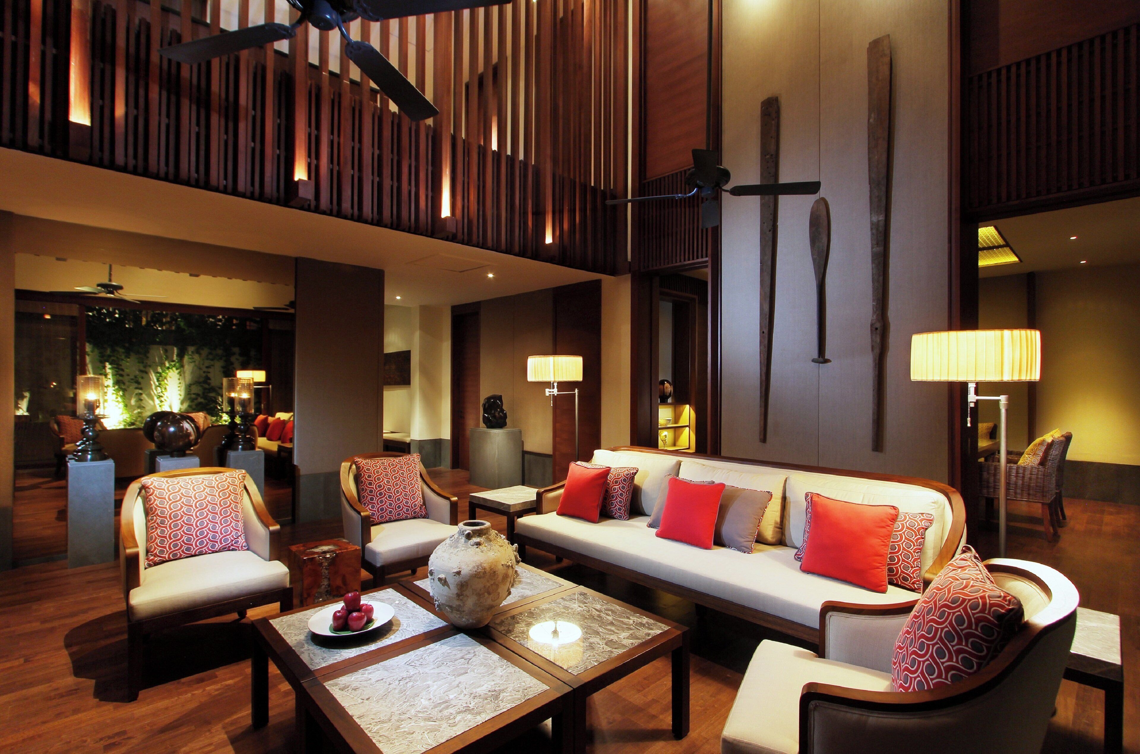 A spacious lobby with a modern design, featuring a sofa set, armchairs, and a coffee table.