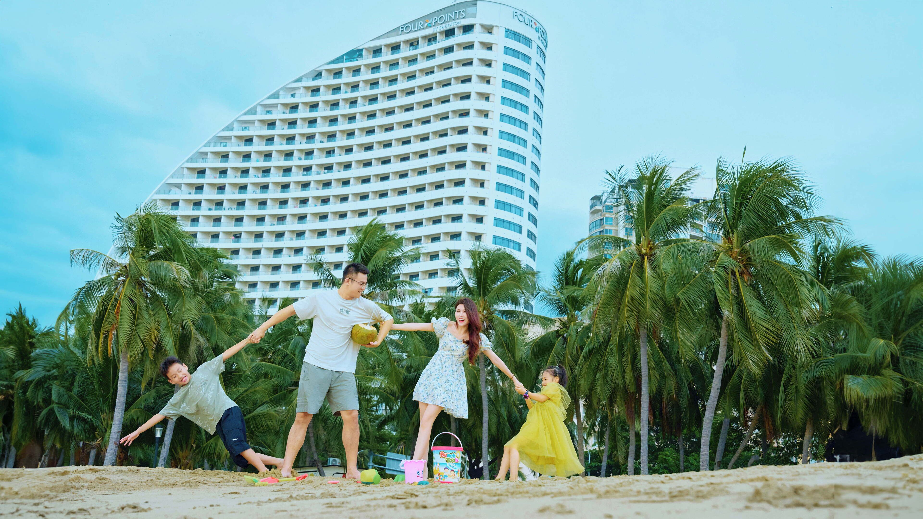 A beachfront hotel with a modern curved building, palm trees, and a sandy beach.