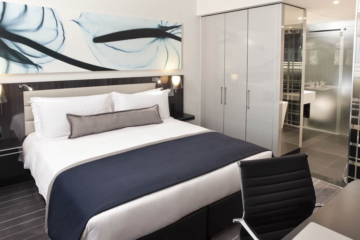 Une chambre d’hôtel moderne, dotée d’un grand lit, d’un bureau et d’une armoire.