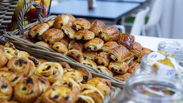 A variety of pastries displayed in baskets and jars, with a wicker basket and a glass jar visible in the foreground.