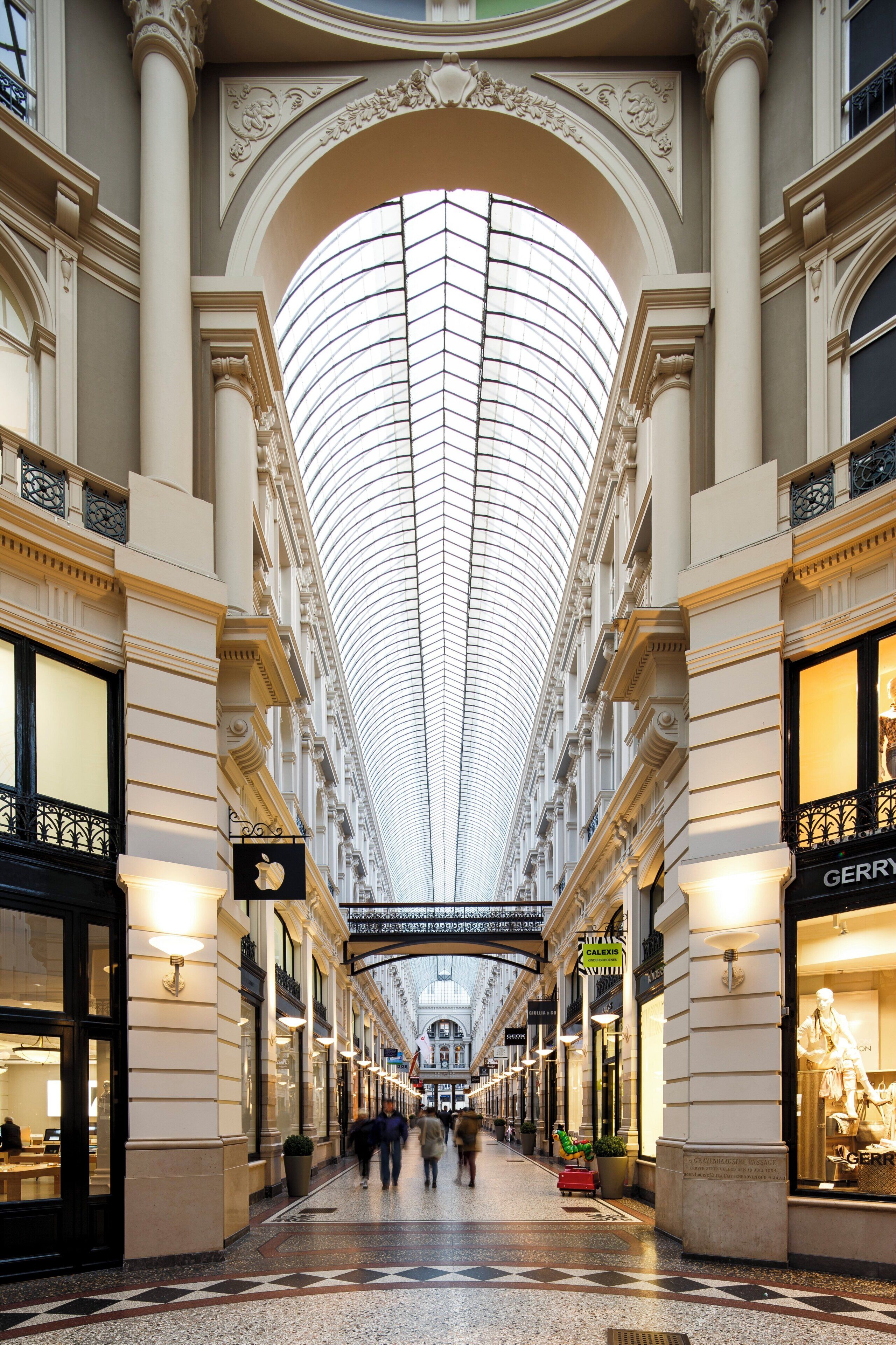 A spacious indoor shopping area with a high, arched ceiling and multiple levels of shops.