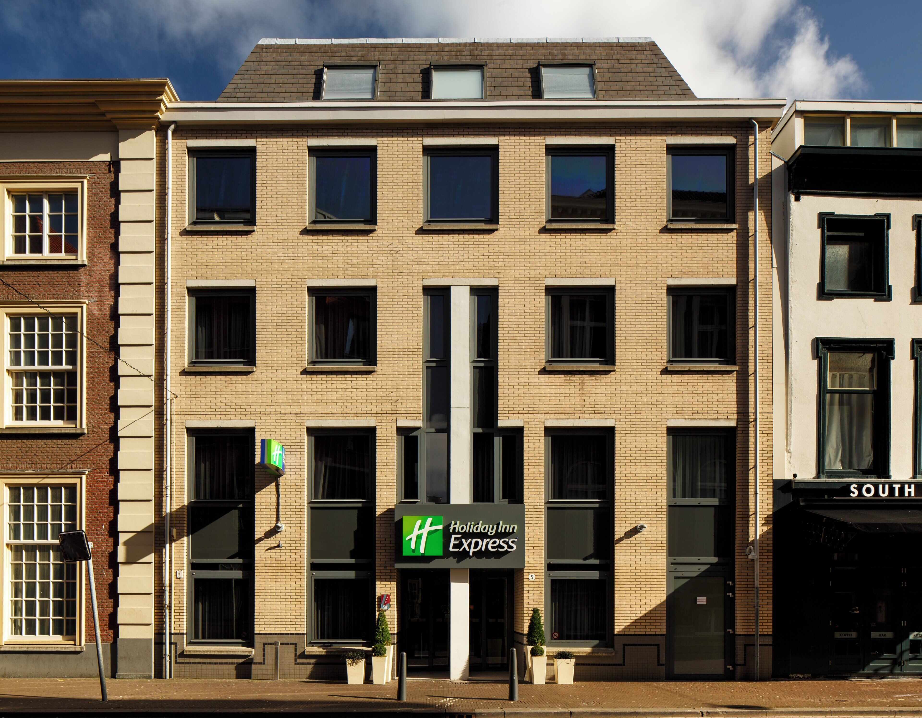 Ein Holiday Inn Express Gebäude mit Backsteinfassade, zahlreichen Fenstern und einer Beschilderung des Markenlogos.