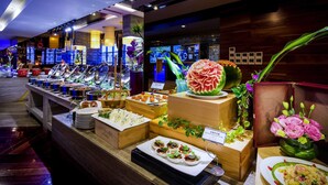 Ein Buffet mit verschiedenen Speisen und einer dekorativen Wassermelone als Mittelpunkt.