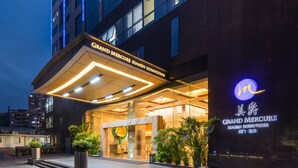 Ein Hotel Eingang mit modernem Design, mit einem auffälligen Schild für "Grand Mercure Xiamen Downtown".