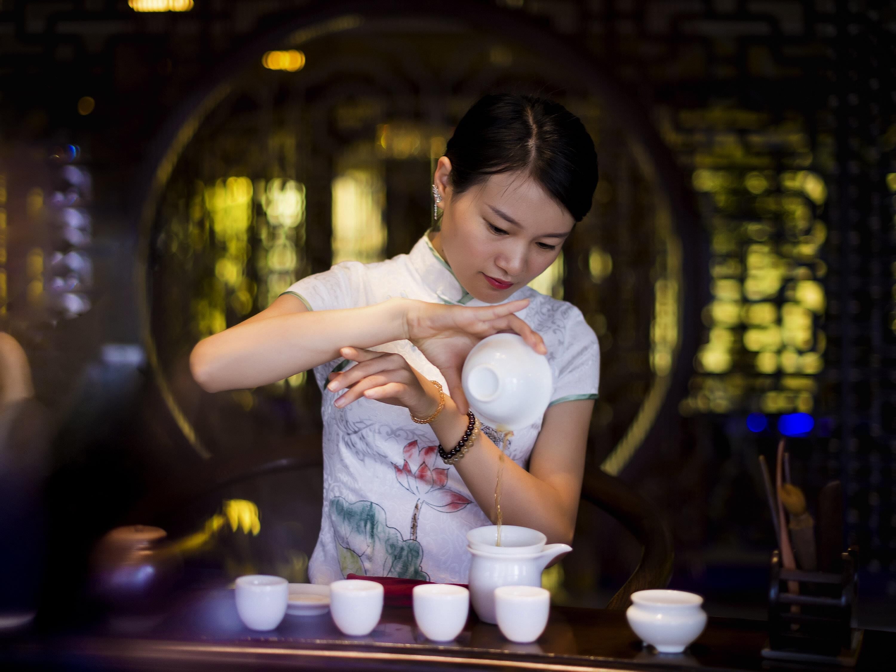 A person pouring tea into a cup.