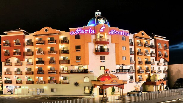 Un hotel de varios pisos con balcones y una estructura cúpula central, llamado "Maria & Bonita".
