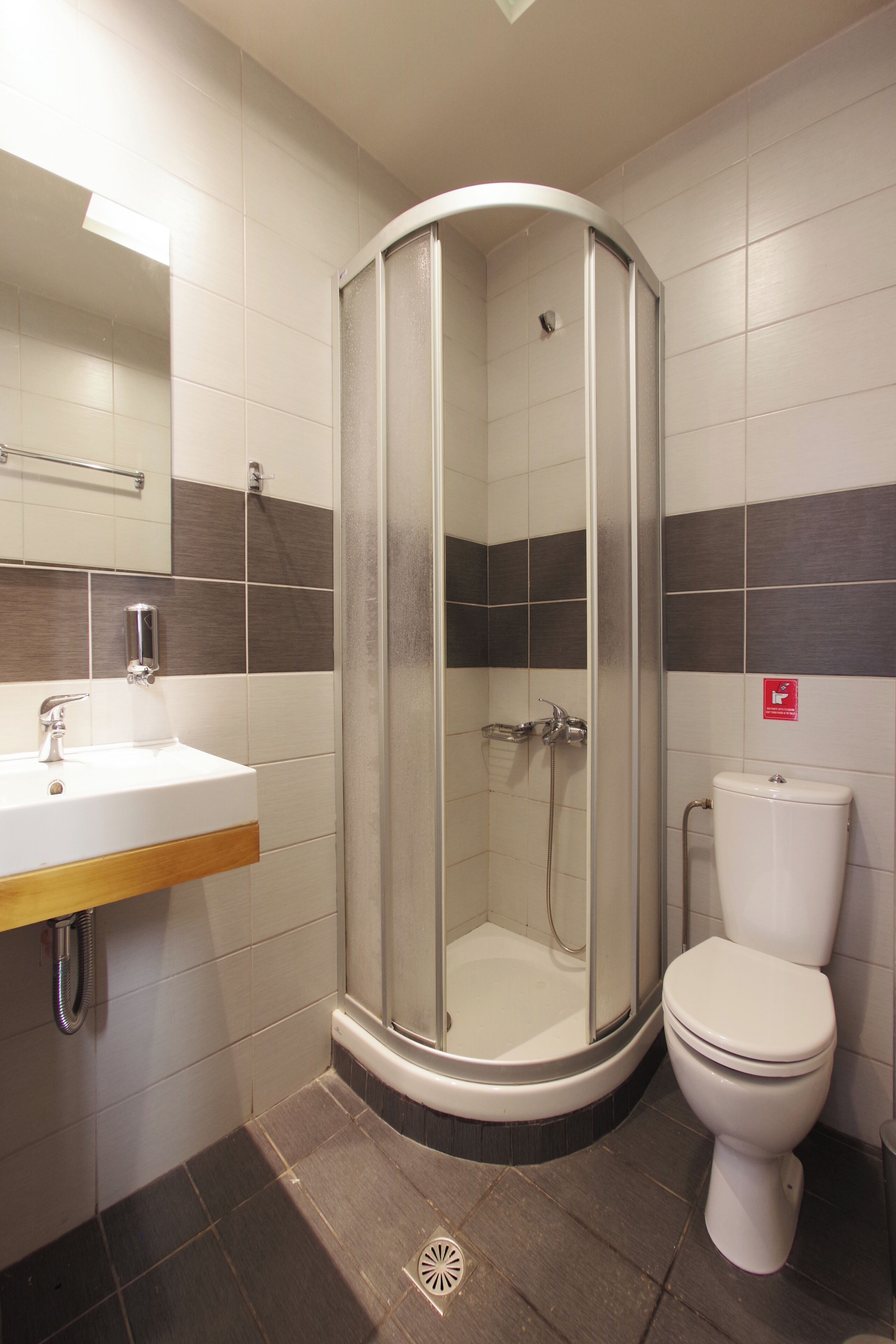 A bathroom with a shower, sink, and toilet.