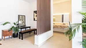 A modern bathroom with a marble sink, a large mirror, and a wooden bench. - Cambodian Country Club (Phnom Penh)